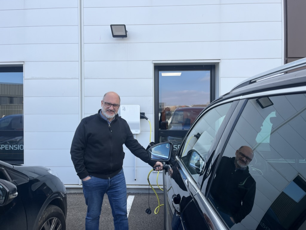 Pourquoi ma voiture électrique ne charge plus ? Diagnostic et solutions 1 Homme utilisant une borne de recharge pour recharger la batterie de son véhicule électrique.